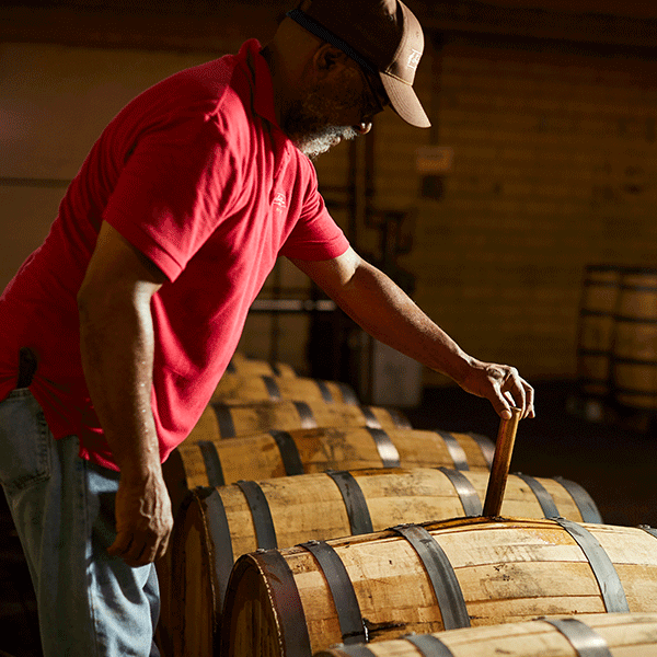 A. Smith Bowman Distillery worker checking the bourbon barrels